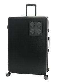 Svart hårdskridskoffert med teleskophandtag, fyra hjul och en LEGO-temad texturerad tillbehörspanel med fyra LEGO-naglar.