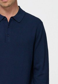 Polo cu mâneci lungi de culoare bleumarin, realizat dintr-un material tricotat texturat, având un guler clasic și un placket cu trei nasturi, cu un design slim fit.