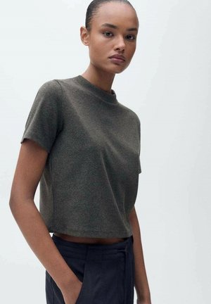 Donkergroene, korte katoenen t-shirt met korte mouwen en een geribbelde halslijn. Gladde textuur, minimalistisch ontwerp en een relaxte pasvorm.