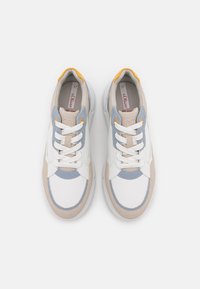 Baskets avec un mélange de daim et de cuir blanc, bleu clair et beige. Elles présentent un bout rond, des lacets blancs et un accent jaune doux au niveau du talon.