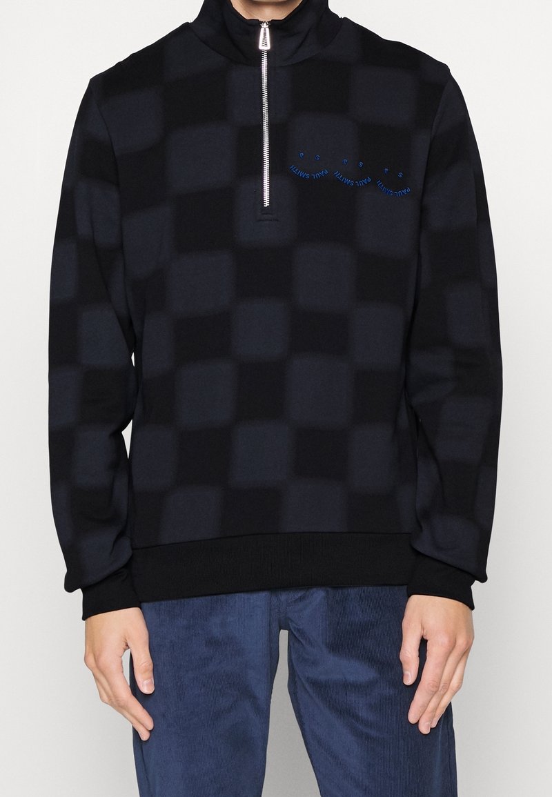 Pullover a mezze zip in tessuto check nero e blu, realizzato in un materiale morbido, con polsini a coste e un piccolo logo sul petto.