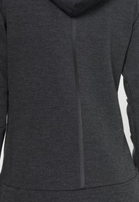 Veste à capuche gris foncé avec une fermeture éclair noire verticale au centre du dos, vue de dos.