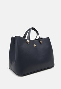 Borsa a spalla in pelle blu navy con finitura testurizzata, dettagli in metallo dorato e doppio manico; presenta un logo prominente sul davanti.