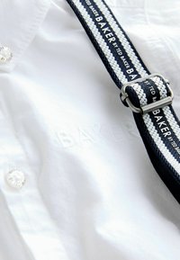 Balta marškiniai su subtiliu siuvinėjimu "BAKER", navy ir baltos spalvos audiniu bei sidabro metaliniu sagtimi.