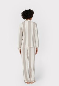 Completo pigiama a righe in morbido cotone, caratterizzato da righe verticali grigie e bianche, vestibilità comoda, maniche lunghe e pantaloni abbinati con orli a costolature.