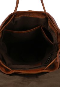 Sac fourre-tout en cuir marron avec un intérieur spacieux, doté d'une doublure en tissu doux et de plusieurs compartiments pour l'organisation.