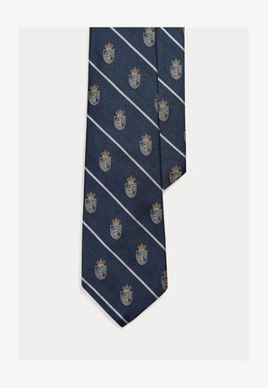 Gravata azul-marinho com padrão repetido de coroas e escudos em dourado e azul, com riscas diagonais brancas e tecido texturizado.