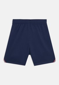 Mørkeblå træningsshorts med elastisk talje, der har en glat tekstur og flerfarvede stribede detaljer ved kanten.