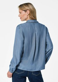 Hellblaues Denim-Hemd mit lässiger Passform, langen Ärmeln und einem Rückenschlitz. Verfügt über einen klassischen Kragen und geknöpfte Manschetten.