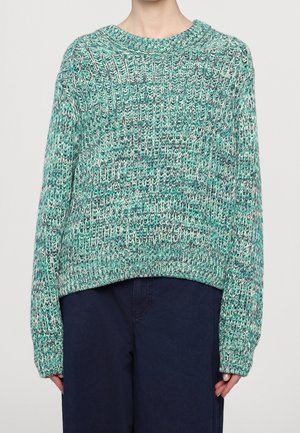 Pull en tricot couleur sarcelle, présentant une coupe ample, une texture côtelée et un col rond. Longueur cropped et manches longues avec des détails de motif subtils.