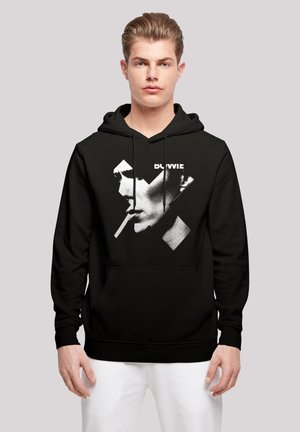 Black hoodie featuring a graphic of a profile with a cigarette, highlighted by contrasting white and gray elements. Drawstrings and front pocket included.