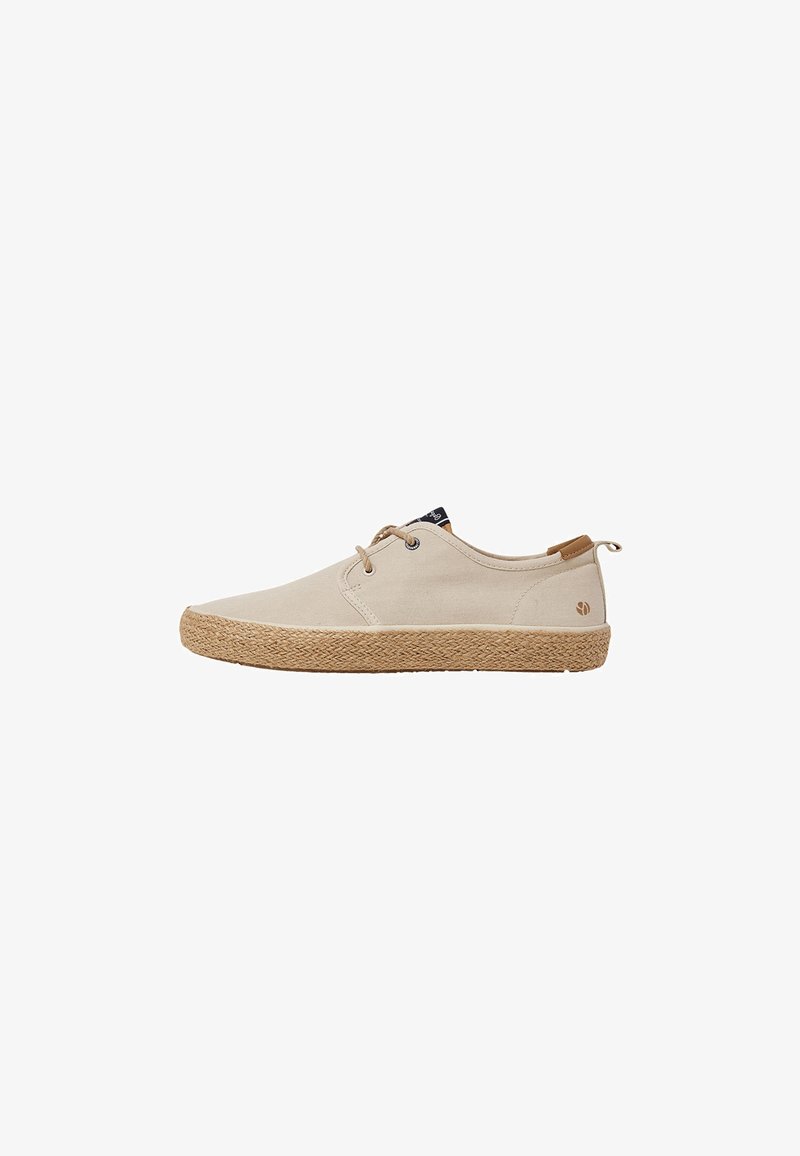 Zapatos de lona beige con suelas de yute, punta redonda y cordones en la parte frontal. Presentan un pequeño logo y detalles en tono marrón en el talón.