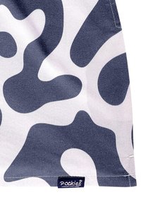 Husă pentru canapea cu un model abstract fluid în nuanța albastru închis pe un fundal deschis. Materialul este neted, iar marginea este cusută cu atenție. Logo-ul este vizibil.