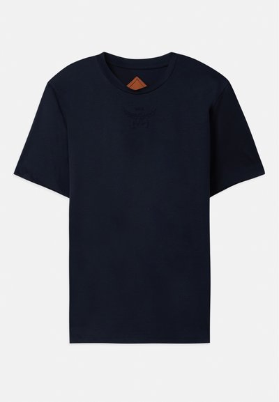 T-shirt en coton bleu marine à manches courtes, avec un col rond et un logo en relief sur la poitrine. Texture lisse, coupe décontractée.
