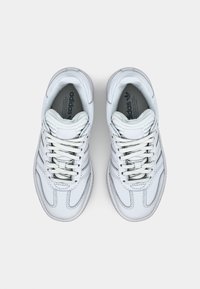 White sneakers with a smooth leather upper, lace-up closure, round toe, and subtle branding on the tongue. Textured rubber sole.