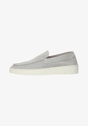 Zapato slip-on de ante gris claro con suela de goma texturizada blanca, tacón bajo y detalles de costura minimalistas.
