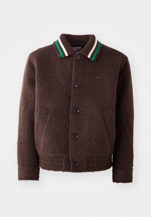 Bruine wolmengsel jas met knoopsluiting, twee voorzakken en een geribbelde kraag met groen en witte strepen. Zacht, textuurstof.
