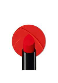Czerwona szminka w czarnym opakowaniu z zaostrzonym końcem. Odpowiednie okrągłe tło ma gładkie, matowe wykończenie.