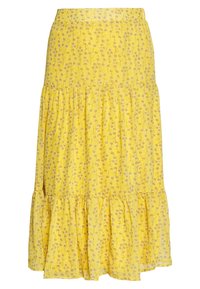 Gul tiered nederdel med små hvide og grå blomsterprint og samlede sømme.