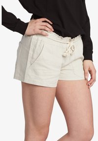 Linen blend shorts in light beige with a gathered waist, drawstring, and front pockets. Features a relaxed fit and smooth texture.