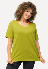 Zelené bavlněné tričko s výstřihem do V, krátkými rukávy a kontrastním oranžovým a bílým lemováním kolem výstřihu. Volný střih.