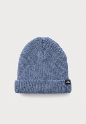 Light blue knitted beanie with folded cuff and small black tag featuring a white logo on a white background.