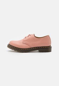 Chaussure à lacets en cuir rose, coupe basse, semelle épaisse noire avec couture jaune, vue de profil extérieur sur fond blanc.