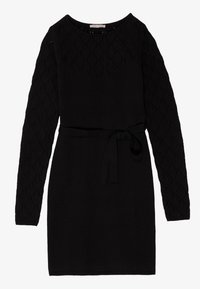 Robe en tricot noir avec de longues manches à motif losangé et une ceinture à la taille. Encolure ronde et design à ourlet droit.