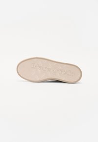 Šviesiai beige spalvos sportinių batų padas su žuvies kaulo raštu, įspausdintu "Marc O'Polo" logotipu ir lygiais kraštais. Tekstūruota guma, užtikrinanti sukibimą.