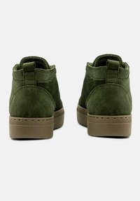 Zielone zamszowe botki za kostkę o miękkiej fakturze, okrągłym nosku i brązowej gumowej podeszwie. Prosty design posiada tylną pętelkę ułatwiającą zakładanie.