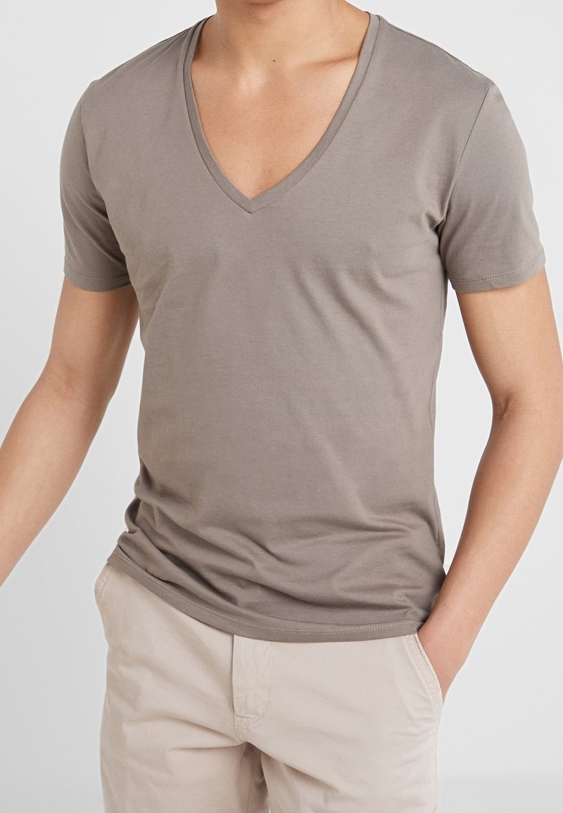 T-shirt z krótkim rękawem i dekoltem w serek w jasnobrązowym kolorze, dopasowany krój z gładką fakturą, bezszwowe rękawy i prosty krój dołu.