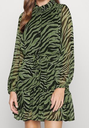 Robe transparente verte à rayures noires de tigre, manches longues, col montant et taille ceinturée. Comprend une jupe plissée et un devant à boutons.