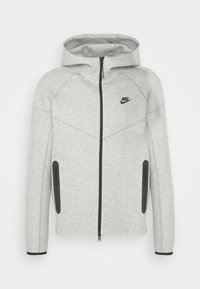 Harmaa Nike-huppari, jossa on vetoketju edessä, huppu, raglan-hihat, musta vetoketju ja korostukset, kaksi sivutaskua ja logo rinnassa.