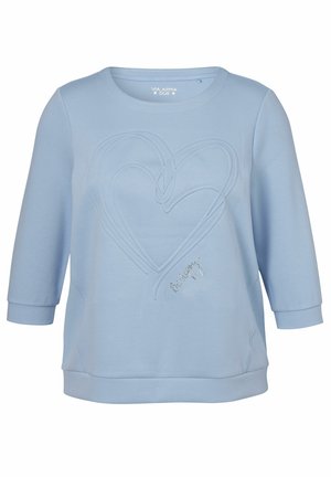 Sweat-shirt bleu clair à manches trois-quarts avec deux cœurs embossés superposés et un petit texte en cursive sur le devant.