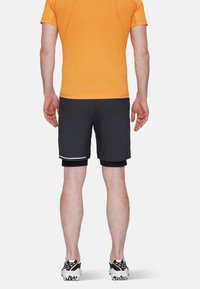 Herrträningsoutfit med en klar orange t-shirt med kort ärm och svarta shorts med vita detaljer, tillverkad av lätt och fuktavvisande tyg.