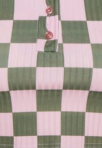 Camicia a quadri con strisce alternate rosa e verde, con una texture a coste e tre bottoni rosa all'apertura del collo.