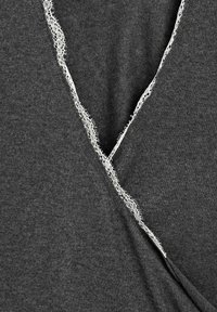 Tissu gris foncé avec un décolleté en V orné d'une délicate dentelle blanche, présentant une texture douce et des détails de couture raffinés.