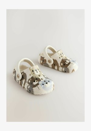 Camouflage-patterned clogs with bear faces in earthy tones, featuring a sturdy strap for secure wear. Positioned against a light backdrop.