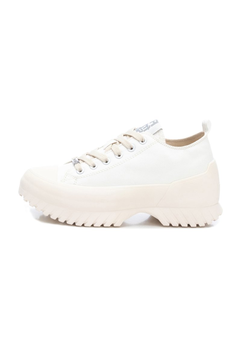 Zapatillas de lona blancas con suela de goma, fondo texturizado y acentos en beige. Cuentan con cordones y una pequeña pestaña en el talón.