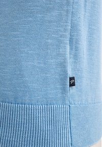 Pulover tricotat de culoare albastru deschis, cu tiv și mansete cu nervuri, având un mic eticheta de marcă coasă pe lateral. Textură netedă pe întreaga suprafață.