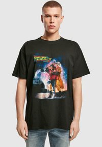 Black cotton t-shirt featuring a vibrant graphic print from "Back to the Future II," depicting characters and a car against a colorful background.