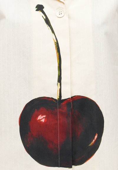 Μεγάλο σκοτεινό κόκκινο γραφικό κερασί με μακριά κοτσάνι, τυπωμένο σε λευκό ύφασμα κοντά σε λευκό κουμπί.