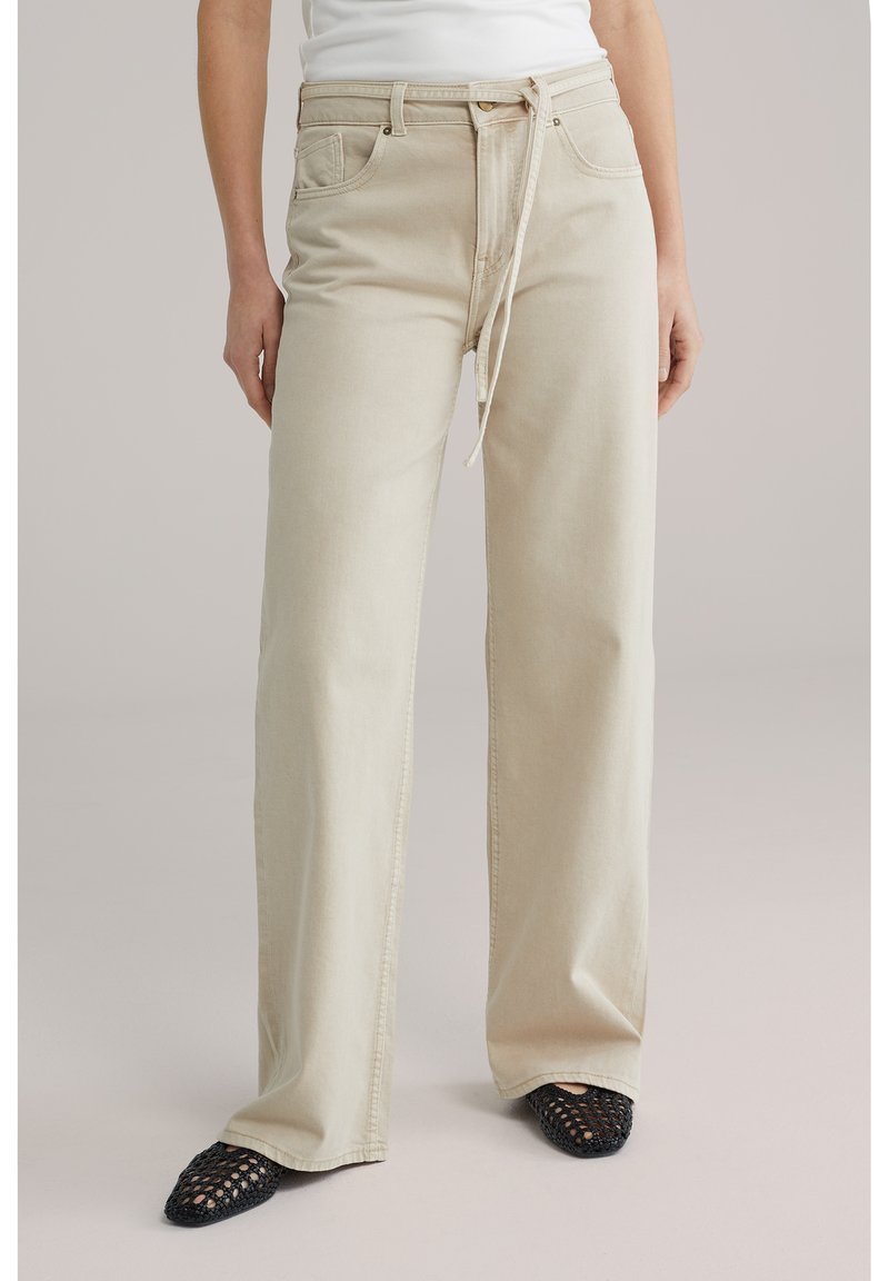 Beežid laia lõikega teksad kõrge vöökohaga ja paelaga kinnitusega. Valmistatud pehmest teksast, ees taskud ja lõdvestunud lõige.