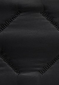 Crna tkanina s uzorkom mreže, s imenom brenda "lululemon" vezanim u crnoj boji, raspoređenim dijagonalno po površini.