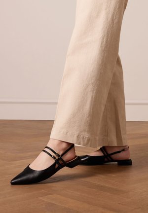 Zwarte leren slingback schoenen met een spitse neus, voorzien van dubbele banden rond de enkels en een lage, vierkante hak.