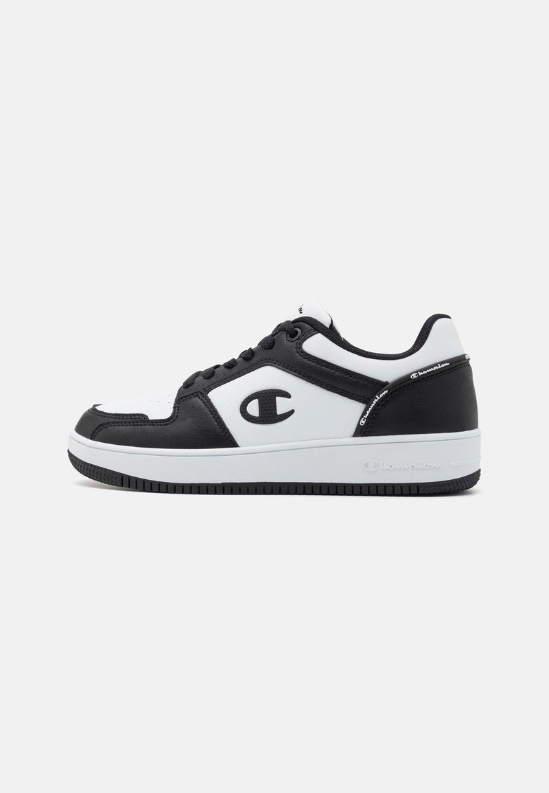 Baskets de sport noir et blanc avec une tige en synthétique, un col rembourré, une boîte à orteils perforée et une semelle en caoutchouc portant le logo Champion.