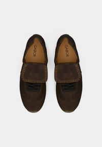 Ζευγάρι χρηστικών παπουτσιών από σκουρό καφέ σουέντ με μαύρα κορδόνια και μεγάλο καπάκι, με την επωνυμία «Gabor» στις ταμπά εσωτερικές σόλες, φωτογραφημένα από πάνω.