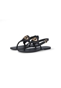 Sandales plates noires présentant un design épuré, avec une bride de cheville ajustable et un accent doré sur le dessus, fabriquées en matériau synthétique.