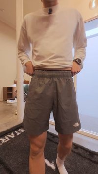 Grå shorts med elastisk midjebånd og sidelommer. Stoffet virker lett og pustende. Logo vist nederst på høyre side.