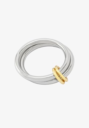 Anillo de metal plateado con un diseño suave y redondeado, que presenta tres bandas entrelazadas y un anillo de acento dorado con un acabado elegante.